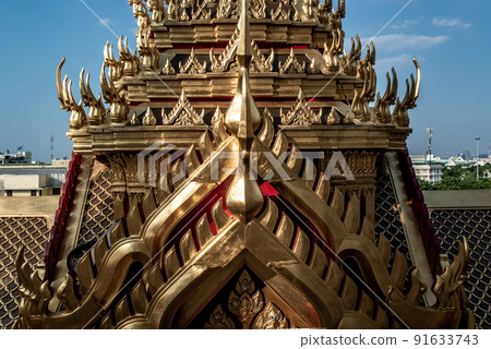 Symmetry view of Loha Prasart Metal Palace at Ratchanaddaram temple through the gate. Loha Prasat Metal Palace is famous tourist destination in Bangkok. 91633743