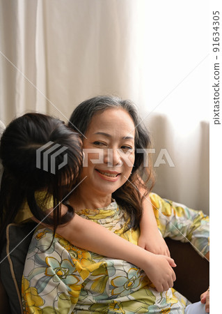 Little grandchild hugging and kissing on cheek her grandmother. Family and love concept 91634305