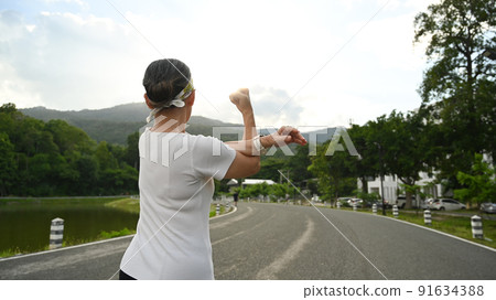 Active healthy middle aged woman stretching arm, warming up before morning workout. Healthy lifestyle, workout and wellness concept Active healthy middle aged woman stretching arm, warming up before morning workout. Healthy lifestyle, workout and wellness concept 91634388