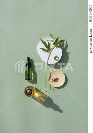 CBD oil in bottle and cannabis bush, hemp, white podium 91634862