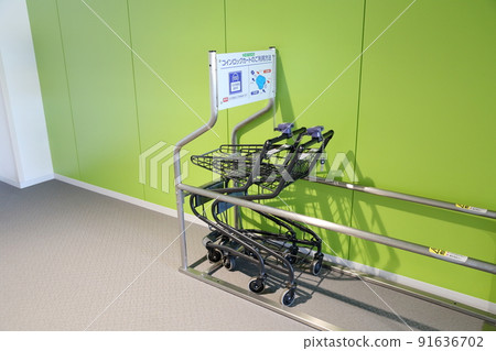 Coin-operated shopping cart chained to the entrance of the supermarket (coin-insertion shopping cart) 91636702