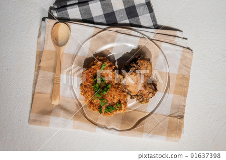 Bowl of east African Jollof Rice garnished with pieces of roasted chicken - top view Bowl of east African Jollof Rice garnished with pieces of roasted chicken - top view 91637398