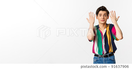 Shocked and annoyed young man shaking hands and looking distressed, standing over white background 91637906