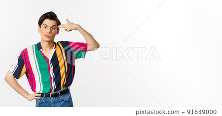 Annoyed gay man making finger gun sign, shooting hismelf from irritation and boredom, standing over white background Annoyed gay man making finger gun sign, shooting hismelf from irritation and boredom, standing over white background 91639000
