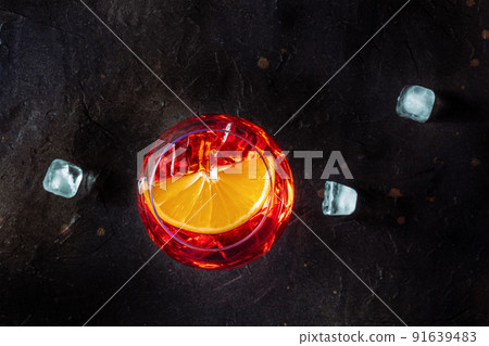 Aperol cocktail with an orange slice and ice cubes, Italian summer cold drink 91639483