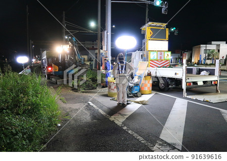 Curbs being removed during nighttime road construction 91639616
