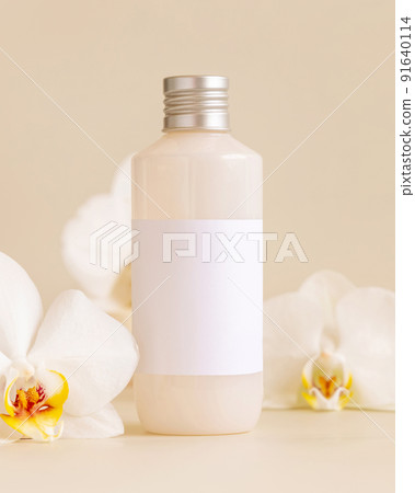 Cosmetic bottle with blank label near white orchid flowers on light yellow, Mockup Cosmetic bottle with blank label near white orchid flowers on light yellow, Mockup 91640114