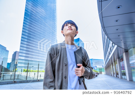 拿著筆記本電腦的辦公室休閒年輕商人 拿著筆記本電腦的辦公室休閒年輕商人 91640792