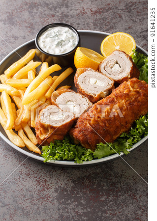 Karageorge Schnitzel Serbian Stuffed Cutlet served with french fries and tartar sauce close-up in a plate. Vertical Karageorge Schnitzel Serbian Stuffed Cutlet served with french fries and tartar sauce close-up in a plate. Vertical 91641235