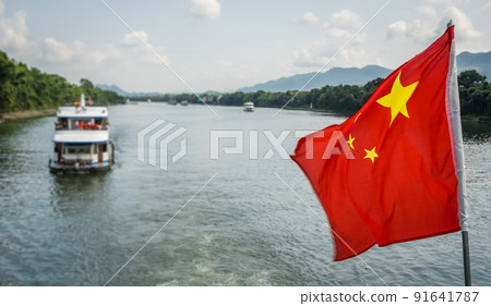 Red Chinese national flag on a boat sailing on Li River Red Chinese national flag on a boat sailing on Li River 91641787
