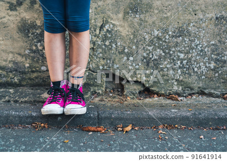 Closeup shot of a girl in stylish pink sneakers Closeup shot of a girl in stylish pink sneakers 91641914
