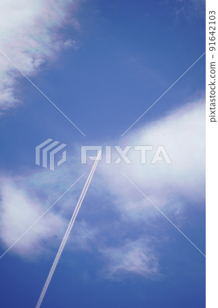 A long contrail traveling in the blue sky A long contrail traveling in the blue sky 91642103