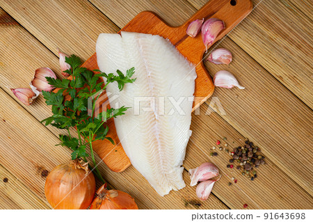 Fillet of raw halibut fish with garlic and greens Fillet of raw halibut fish with garlic and greens 91643698