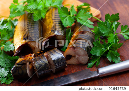 Slices of smoked mackerel served with greens 91643789