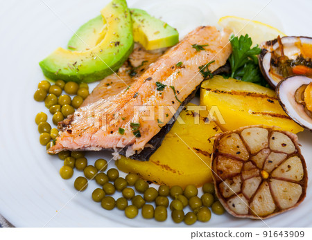 Tasty fried trout fillets, served with seashells, vegetables and avocado 91643909