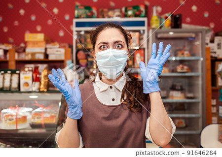 Virus. A woman in rubber gloves and a medical mask throws her hands to the sides in horror, her eyes bulging. Grocery store, small business crisis. Concept of protection against coronavirus 91646284