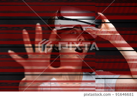 Portrait of young had shocked screaming woman removing VR glasses and reaches hand. Red stripes of online disconnection at foreground. Black background. The concept of metaverse and cyberspace Portrait of young had shocked screaming woman removing VR glasses and reaches hand. Red stripes of online disconnection at foreground. Black background. The concept of metaverse and cyberspace 91646681