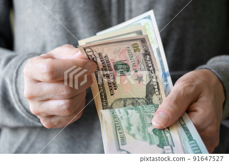 White female count US dollar bills bills in her hands White female count US dollar bills bills in her hands 91647527
