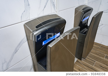 Modern hand dryers in public restroom WC Modern hand dryers in public restroom WC 91648338