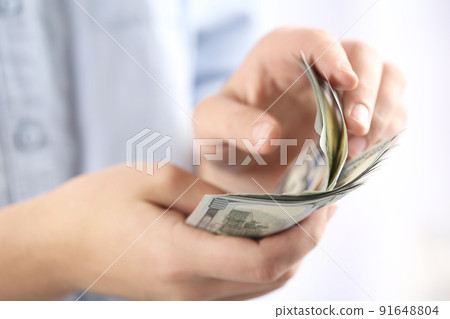 Woman counting money on blurred background, closeup 91648804