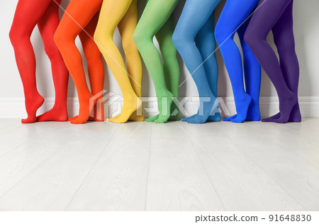 Women wearing colorful tights near white wall, closeup 91648830