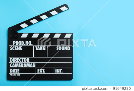 Clapper board on light blue background, top view with space for text. Cinema production 91649220