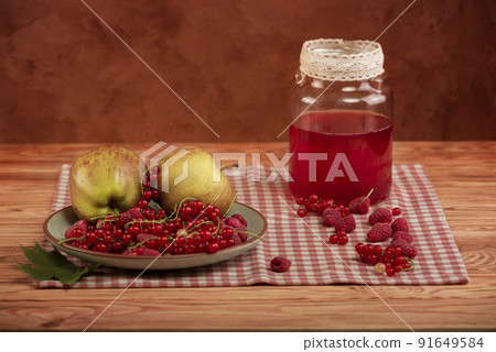 Compote, red currants, raspberries and apples on an old wooden table. Compote, red currants, raspberries and apples on an old wooden table. 91649584
