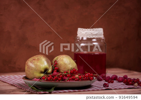 Compote, red currants, raspberries and apples on an old wooden table. 91649594