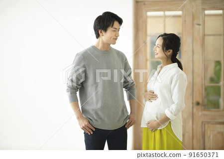 A couple talking with a hand in the tummy of a pregnant woman A couple talking with a hand in the tummy of a pregnant woman 91650371