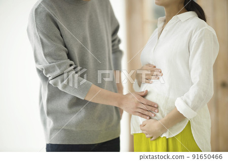 A couple talking with a hand in the tummy of a pregnant woman A couple talking with a hand in the tummy of a pregnant woman 91650466