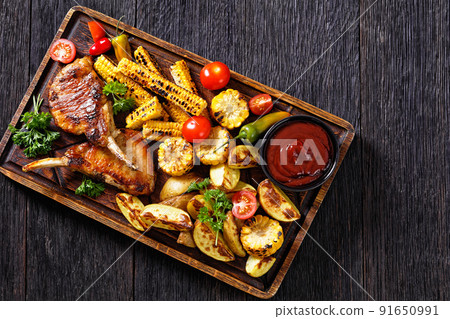bbq tomahawk pork chop with corn and potatoes bbq tomahawk pork chop with corn and potatoes 91650991