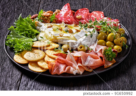 savory baked brie with crackers, salami, nuts, ham savory baked brie with crackers, salami, nuts, ham 91650992