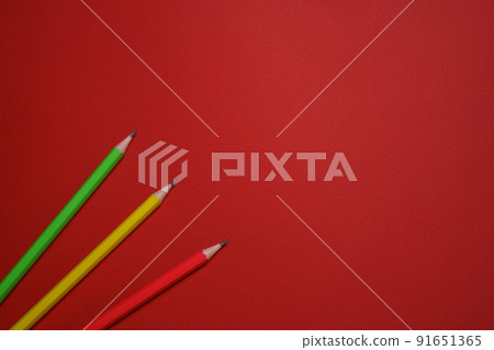 Colored wooden pencils scattered on red background, education concept. Colored wooden pencils scattered on red background, education concept. 91651365