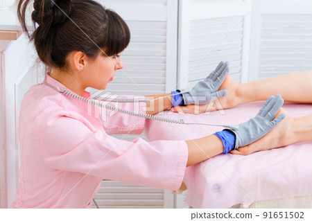 Masseuse makes an anti-cellulite massage on legs. Micro-sensory electric 91651502