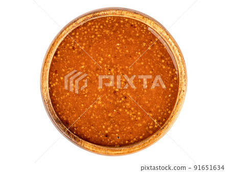 Top view of a wooden bowl full of Bavarian mustard on a white background. Top view of a wooden bowl full of Bavarian mustard on a white background. 91651634