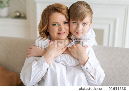 Happy woman have fun with cute baby boy 5-6-7 years old in white shirt. Mom 91651888