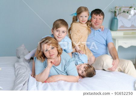 Cheerful family playing together on bed. Parents spend their free time 91652250