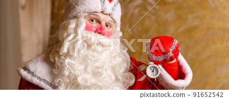 Happy santa with alarm clock showing five minutes to midnight. 91652542