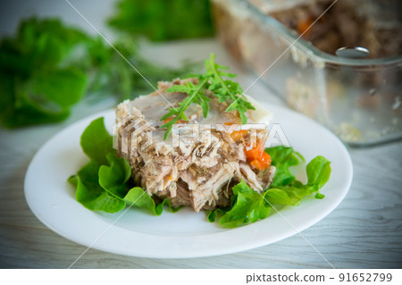 jellied meat with greens and vegetables in a plate 91652799