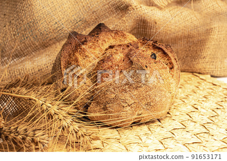 Round bread close-up. Freshly baked sourdough bread with a golden crust. Baker shop context with delicious bread. 91653171