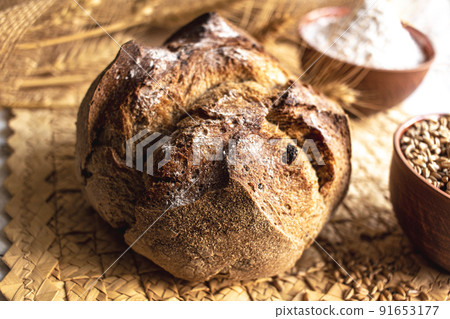 Round bread close-up. Freshly baked sourdough bread with a golden crust. Baker shop context with delicious bread. 91653177