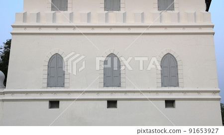 dusty white ancient building facade with beautiful gray wooden windows. 91653927