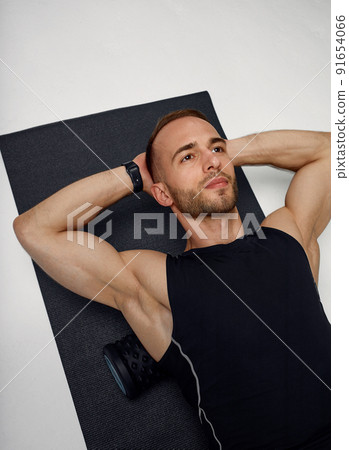 Man foam rolling. Athlete stretches using foam roller. Man foam rolling. Athlete stretches using foam roller. 91654066