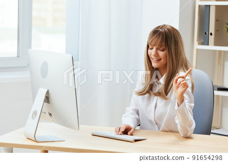 Happy smiling adorable blonde businesswoman typing answer for client look aside sitting at workplace in light modern office. Cheerful employee work on computer online in support service. Copy space Happy smiling adorable blonde businesswoman typing answer for client look aside sitting at workplace in light modern office. Cheerful employee work on computer online in support service. Copy space 91654298