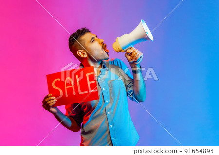Portrait of smiling happy man in shirt paying attention announcing big sale yelling at loudspeaker, black Friday shopping. Indoor studio shot isolated on colorful neon light background. Portrait of smiling happy man in shirt paying attention announcing big sale yelling at loudspeaker, black Friday shopping. Indoor studio shot isolated on colorful neon light background. 91654893