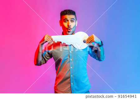 Portrait of astonished man in shirt holding huge paper key and being amazed to get new home, real estate purchase, rental service. Indoor studio shot isolated on colorful neon light background. Portrait of astonished man in shirt holding huge paper key and being amazed to get new home, real estate purchase, rental service. Indoor studio shot isolated on colorful neon light background. 91654941