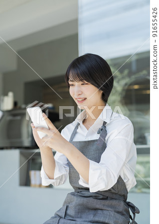 使用咖啡館智能手機的女性職員 91655426