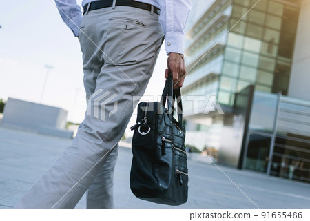Businessman holding briefcase going to work Businessman holding briefcase going to work 91655486