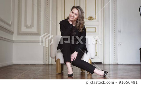 a funny and attractive woman in a black suit in the chair a funny and attractive woman in a black suit in the chair 91656481