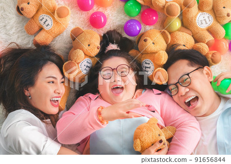 Happy Asian family laying on carpet in living room and smile with their daughter down syndrome child , a lot color balls and teddy bear dolls around them , Activity happy family lifestyle concept. Happy Asian family laying on carpet in living room and smile with their daughter down syndrome child , a lot color balls and teddy bear dolls around them , Activity happy family lifestyle concept. 91656844